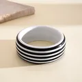 Primer plano de un brazalete de resina a rayas blancas y negras en un fondo neutro - Rayas Blancas y Negras