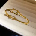 Detailaufnahme eines 18K vergoldeten Armbands mit Zirkonia-Steinen und Kordeldesign. - Gold