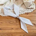 Close-up detail of resort style polka dot fabric necklace featuring a resin flower buckle - Four-Petal Flower Clasp / White Polka Dot