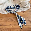 Detailed view of floral print fabric necklace with a silver resin pearl bead accent - Resin Bead Buckle / Blue and Yellow Print