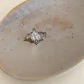 Vista dettagliata di un anello a stella in zircone su un piatto di ceramica strutturato. - Stile Stella a Quattro Punte (7#) / Pezzo Singolo / Argento