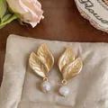 Vista detallada de los pendientes de hoja dorada con perlas naturales de agua dulce - Estilo de Hoja / Dorado