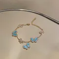 Detailansicht eines eleganten goldfarbenen Schmetterlingsarmbands mit blauer Emaille und Zirkonia - Gold-Blau