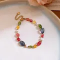 Detailed view of vibrant multi-colored stone beads and white pearls on gold chain. - Bracelet / Colorful