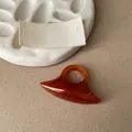Close-up of an amber resin statement ring with a unique geometric oval shape - Orange