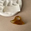 Macro view of a minimalist amber resin ring with unique oval sculptural design - Light Coffee