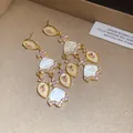 Vue détaillée de boucles d'oreilles vintage avec des zircons roses et de l'acétate blanc - Blanc