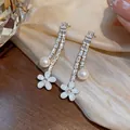 Detailed macro view of elegant zircon flower drop earrings with round white pearls. - Silver-Blue