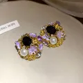 Detailed close-up of vintage purple enamel flower earrings with pearls and crystals. - Gold / Purple