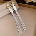 Vue détaillée de boucles d'oreilles vintage fleurs émail bleu et glands argentés - Bleu