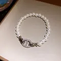 Detailansicht eines Perlenarmbands im französischen Vintage-Stil mit Kristall-Verschluss. - Strass-besetzter Ankerketten-Stil / Silber mit weißer Perle