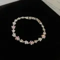 Primo piano dettagliato di un braccialetto di fiori scintillanti in zircone e perle - Bracciale / Argento-Rosa