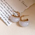 Macro view of vintage C-shaped resin earrings with elegant gold-tone metal accents - Silver Pin-Gold-White