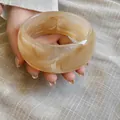 Vista macro de brazalete ancho de acrílico con elegante patrón jaspeado beige - Caqui Difuminado