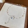 Detailed macro view showing the elegant pearl beaded necklace and flower pendant. - Necklace / White