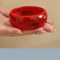 Detalle de un brazalete ancho de acrílico con motivos jaspeados en rojo y negro - Rojo Jaspeado