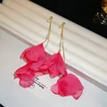 Dettaglio di eleganti orecchini a fiore in tessuto rosa con delicate catene dorate. - Stile Nappa in Pietra di Chiffon