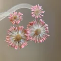 Primo piano di orecchini a fiore in tessuto rosa stile foresta con centri dorati. - Stile Nucleo in Tessuto Radiale