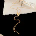 Close-up detail of a textured golden crumpled heart pendant on a sleek snake chain - Necklace / Gold