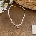 Detail of French style twisted pearl necklace featuring a pink square zircon pendant. - Necklace-Gold-White-Pink-Square