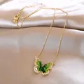 Detailed view of the gold necklace featuring a vibrant green gradient butterfly pendant. - Green Gradient Butterfly Style