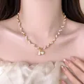 Close-up of elegant gold pearl necklace with crystal bear pendant on a model - White Artificial Pearl Style
