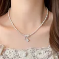 Detailed view of elegant white pearl necklace with sparkling crystal pendant on model - Pink Artificial Pearl Style