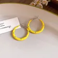 Primer plano de pendientes de aro de esmalte amarillo con lunares azules y postes de plata - 3cm de Diámetro / Amarillo con lunares
