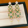 Detailed macro shot of 18k gold plated court style earrings with pink and green stones - Gold