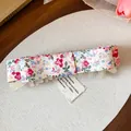 Close-up detail of a floral fabric bow hair clip featuring a vintage cotton tag. - Twist Clip / Single Piece / Multicolor (Floral)