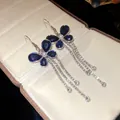 Detailed view of elegant blue crystal butterfly earrings with long rhinestone tassels - Blue-White