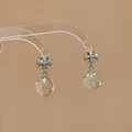 Silver cross earrings featuring clear glass orb drops with colorful polka dot patterns - Cross Style