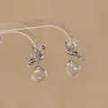Elegant silver butterfly dangle earrings featuring a clear resin sphere with colorful polka dots. - Butterfly Design