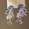 Vue détaillée de boucles d'oreilles en perles violettes avec gouttes de cristal. - Style Tige d'Oreille en Argent / Bleu Violet