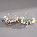 Detailed view of colorful glass beads and faux pearls on silver-tone heart hoop earrings. - Heart Flower Style / Colorful