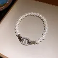 Elegantes Perlenarmband mit einem schimmernden, mit Zirkonia besetzten Verschluss. - Silber-Weiß