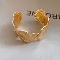 Detailed macro shot of a gold sea shell textured open cuff bracelet for beach holidays - Ripple Shell Relief Style (3)