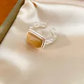 Close-up of a silver chain-link ring featuring a rectangular amber resin centerpiece. - Square Open Ring / Silver-Coffee