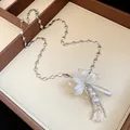Détail d'un collier floral élégant avec perles, chaîne à cœurs et pendentif goutte d'eau. - Argent-Blanc