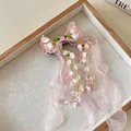 Dettaglio ravvicinato di una molletta per capelli con fiocco in chiffon rosa e mughetti - Fermagli per capelli a becco d'anatra / Fiore Rosa