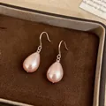 Close-up of peach water-drop pearl earrings resting in a brown velvet jewelry box - Earring Hooks - Silver / Pink