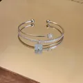 Dettaglio bracciale rigido a doppio strato in argento con zirconi e ciondolo a quadrifoglio - Stile Quadrifoglio a Quattro Foglie / Argento