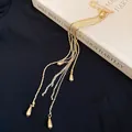 Detailed close-up view of gold waterdrop tassel brooch with vintage safety pin design - Brooch / Gold