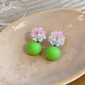 Close-up detail of resin floral stud earrings with vibrant green spherical beads - Green