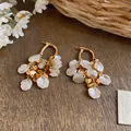 Macro view of French court style pearl petal and gold disc tassel drop earrings for women - Geometric Tassel Style / 925 Silver Needle / Gold-White