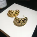 Close-up of vintage 18k gold-plated honeycomb grid earrings with zircon inlay - Stud Earrings / Gold