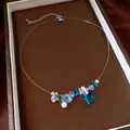 Vista dettagliata dei ciondoli a stella marina blu e conchiglia sulla collana. - Stile Stella Marina e Conchiglia / Bianco E Blu