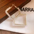 Detailed view of elegant square gold hoop earrings wrapped with clear glass beads - Diamond / Silver Needle / White