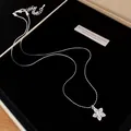 Detailed view of an elegant zircon star pendant necklace resting on black velvet - Silver Style / Silver