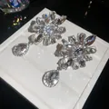 Detailed close-up view of shimmering flower and waterdrop rhinestone clip-on earrings - Flower Water Drop Ear Clip / Silver